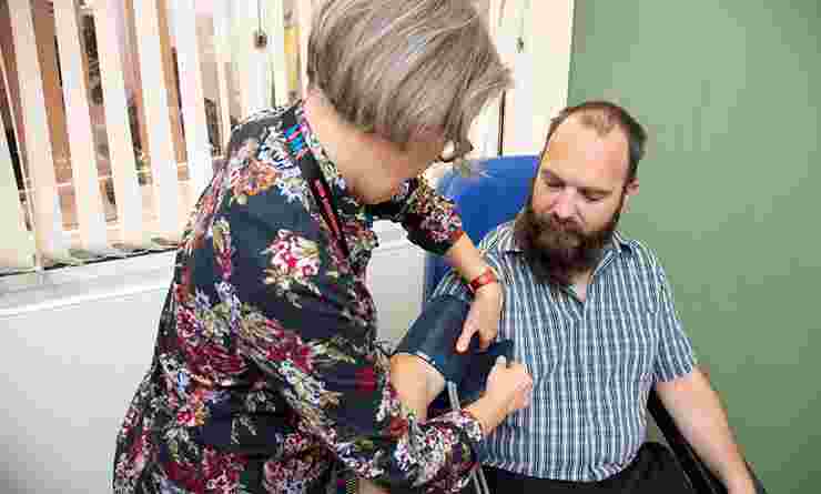 BioResource staff member measures participant Adrian's blood pressure with cuff