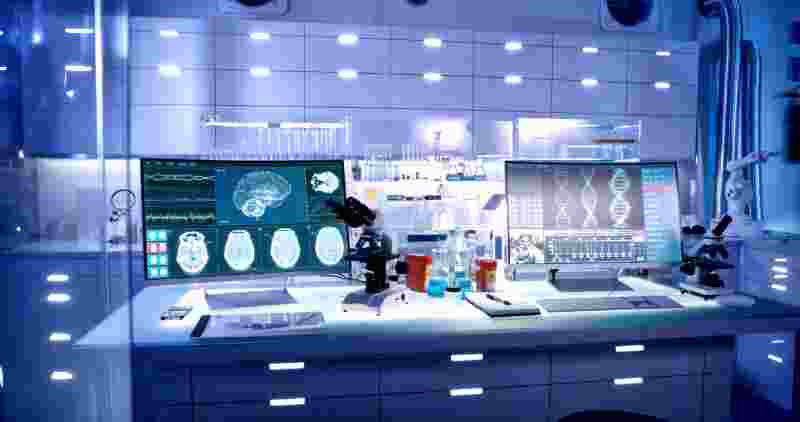 View of lab with microscope, brain scans and DNA on screen